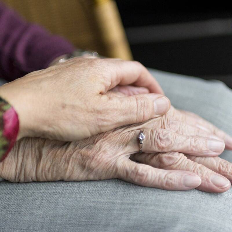 Hand auf Seniorenhand